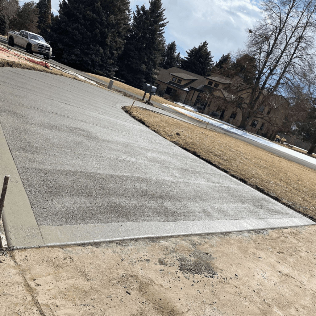 A freshly replaced, spacious, and beautifully finished concrete driveway in Loveland, CO, showcasing expert craftsmanship by Hugo’s Concrete.