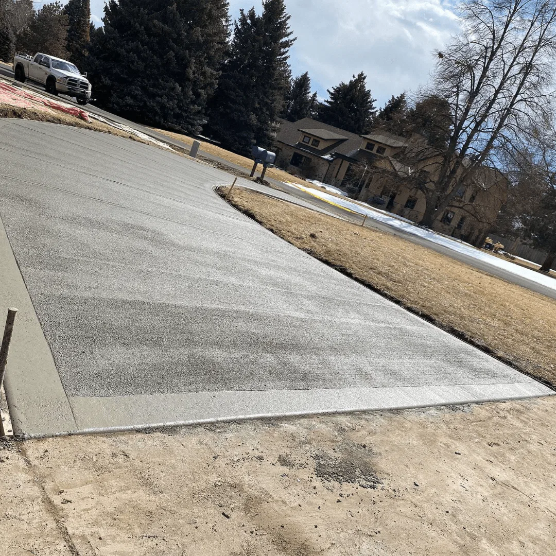 A freshly replaced, spacious, and beautifully finished concrete driveway in Loveland, CO, showcasing expert craftsmanship by Hugo’s Concrete.