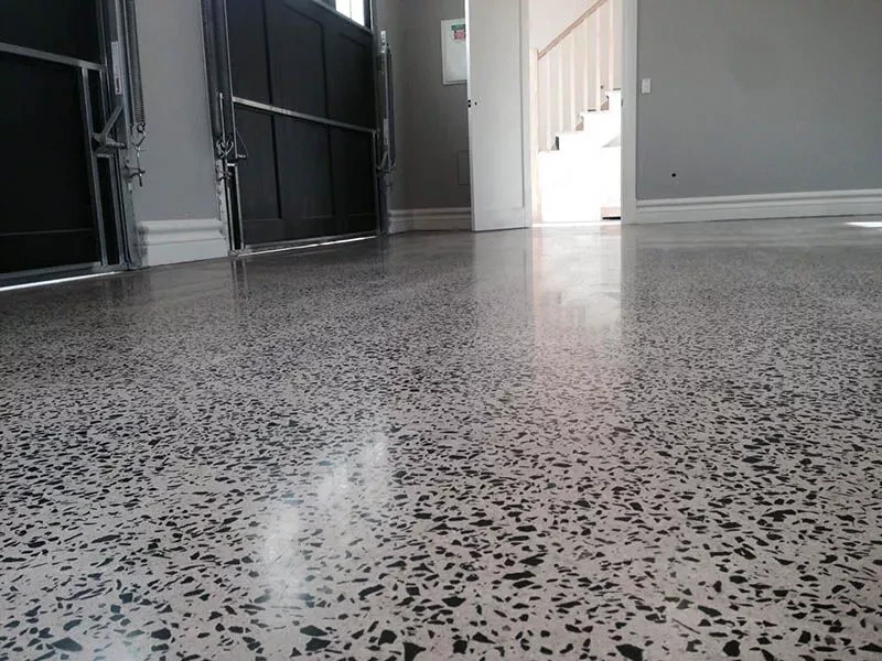 Polished concrete aggregate basement flooring in Loveland Colorado by Hugo's Concrete, featuring exposed aggregate finish with professional sealing