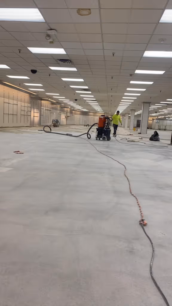 Concrete floor polishing process in progress at a large commercial space. Comparison of Concrete Polishing vs. Epoxy Coating for durable and low-maintenance flooring.