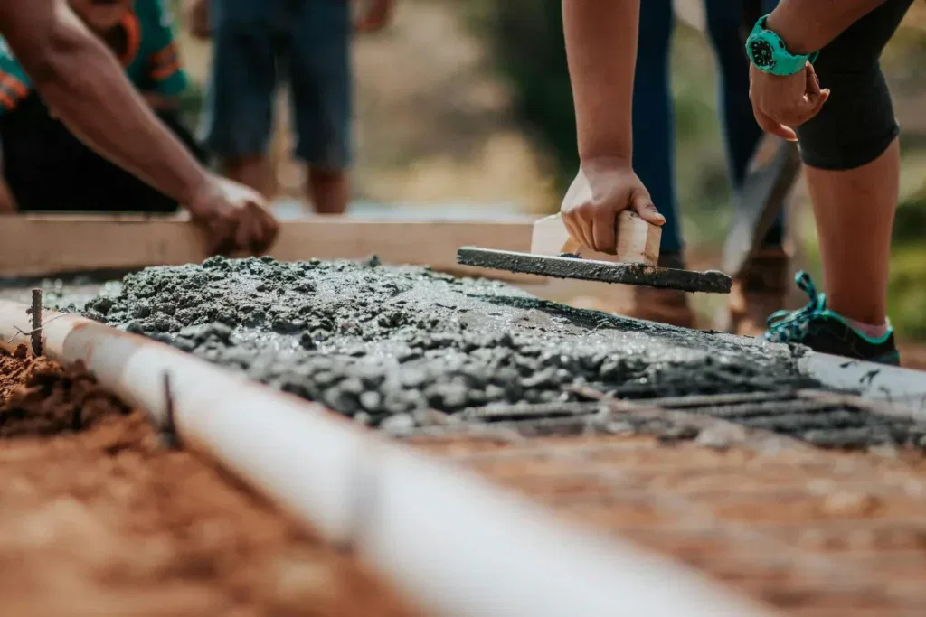 Concrete workers finishing a freshly poured driveway for a homeowner in Loveland, CO