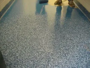 Epoxy flooring with flake finish installed in a Loveland auto repair shop by Hugo’s Concrete, built for durability and easy cleaning