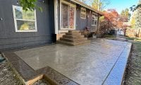 Stamped concrete patio with steps and curved corners installed by Hugo’s Concrete at a residential home in Fort Collins, Colorado.