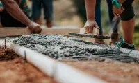 Concrete workers finishing a freshly poured driveway for a homeowner in Loveland, CO