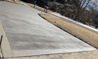 A freshly replaced, spacious, and beautifully finished concrete driveway in Loveland, CO, showcasing expert craftsmanship by Hugo’s Concrete.