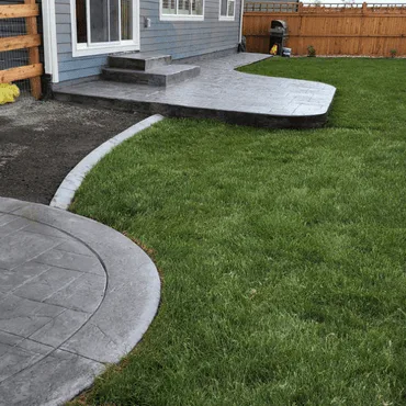 Custom-installed backyard patios for a homeowner in Loveland, CO, featuring two separate concrete patio areas for outdoor living