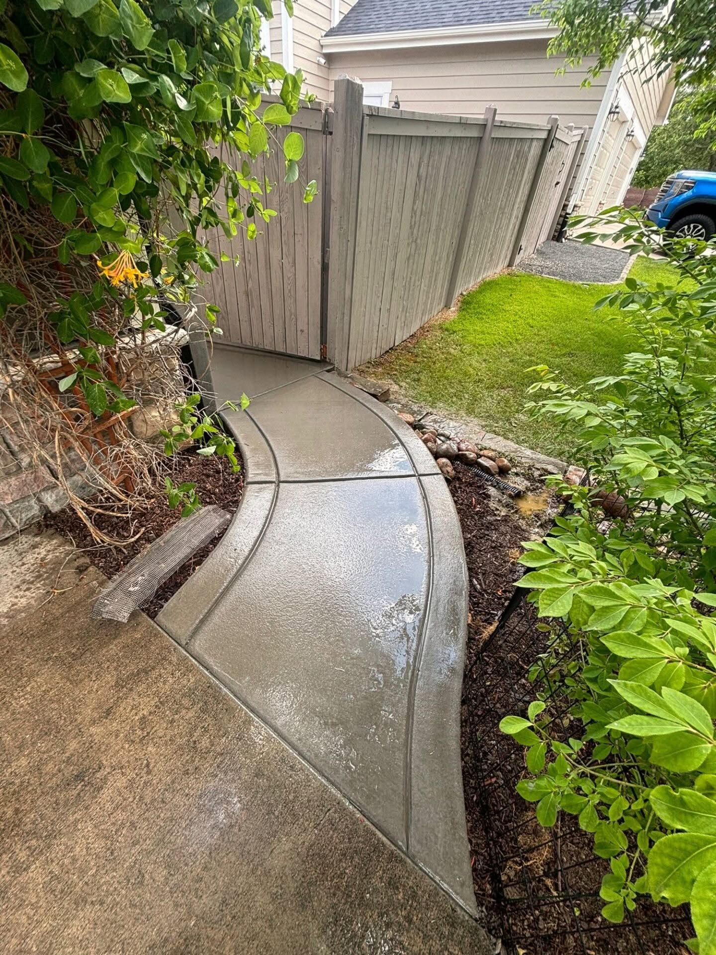 Completed broom finished concrete walkway leading to backyard – Aruba Dr, Fort Collins, installed by Hugo’s Concrete