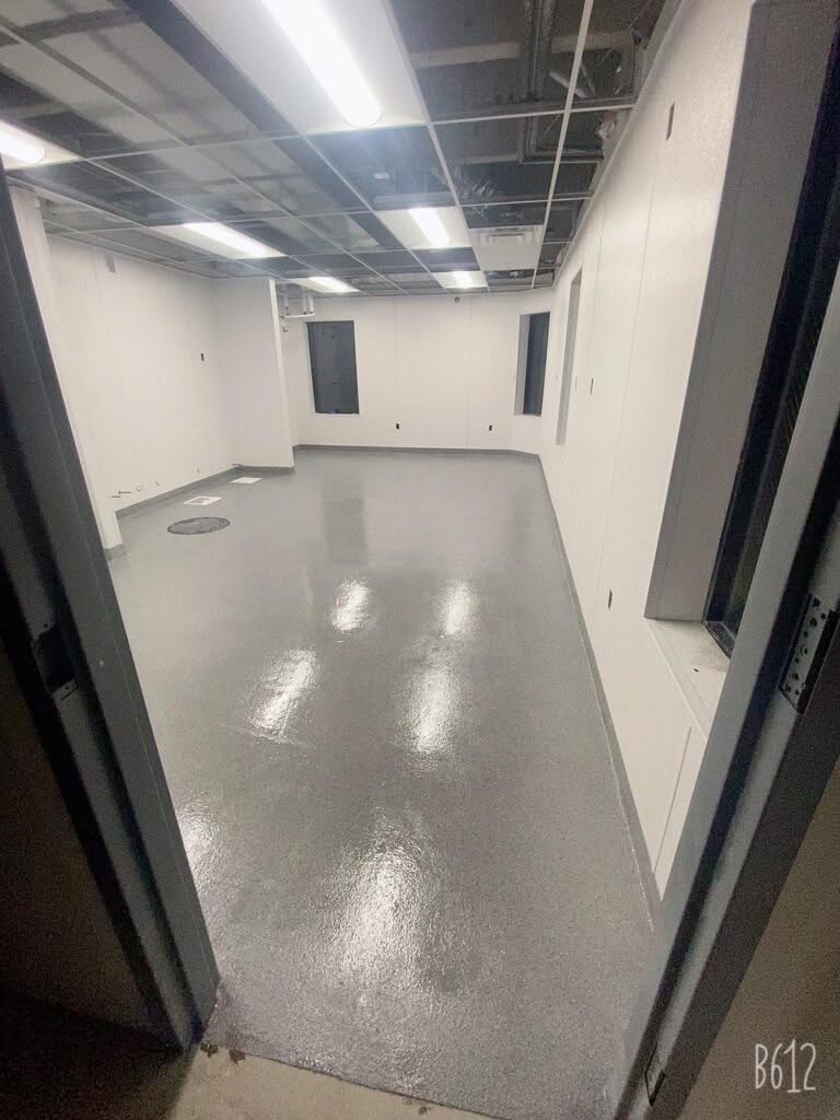 Finished epoxy garage floor with a smooth, high‑gloss coating installed in a Fort Collins business