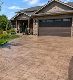 Colored concrete driveway with a warm brown finish in front of a Loveland, CO home.
