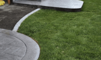Custom-installed backyard patios for a homeowner in Loveland, CO, featuring two separate concrete patio areas for outdoor living