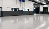 Modern commercial warehouse with professionally finished polished concrete flooring providing a durable, seamless surface for industrial and commercial spaces.