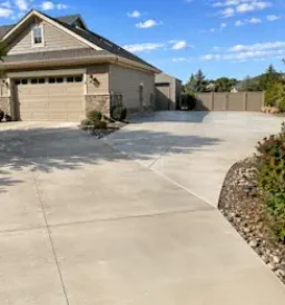 Concrete driveway extension providing extra parking space beside a Loveland, CO home.
